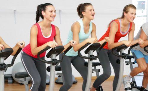 plusieurs femmes faisant du spinning