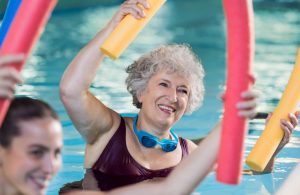 Une dame âgée faisant de l'aquagym dans la piscine