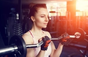 Le barbell curl est un des exercices de bras pour les femmes.