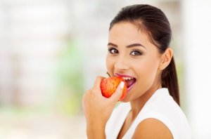 Une femme croque dans une pomme