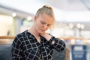 Une femme se masse la nuque
