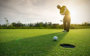 Un joueur de golf qui tire sa balle dans le trou.