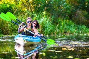 Deux femmes sur un cours d'eau qui font du canoë-kayak.