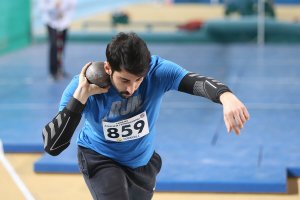 Un sportif qui va lancer un poids.