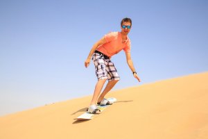 Un homme qui fait du sandboard.