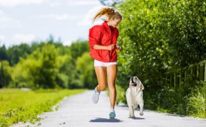 Une femme qui court avec son chien.