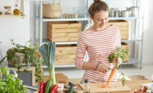 Une femme qui cuisine avec des carottes.