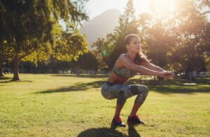 Femme qui fait des squats en nature.