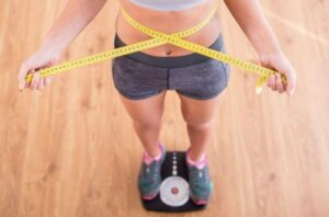 femme sur la balance avec un mètre