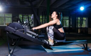 Une femme qui fait du rameur en salle de sport