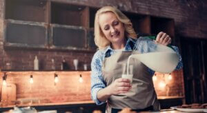 Une femme qui sert un verre de lait.