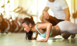 Une femme qui fait des pompes avec un coaching sportif.