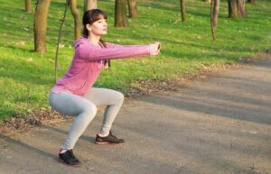 Une femme qui fait ses squats à l'air libre.