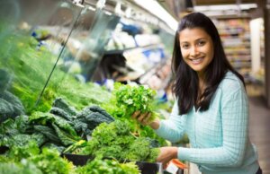 Une femme qui achète des légumes verts.
