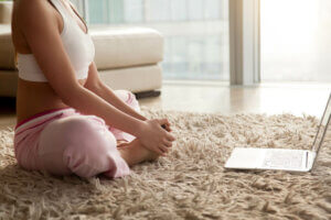 Une femme qui fait du yoga depuis la maison.