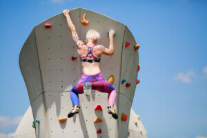 Une femme qui escalade un mur urbain.
