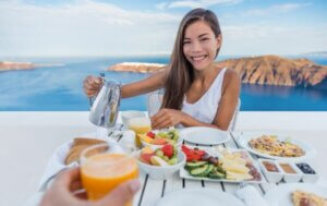 Une femme à table devant la mer.
