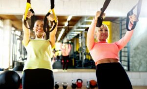 Deux femmes qui s'entraînent avec le TRX.