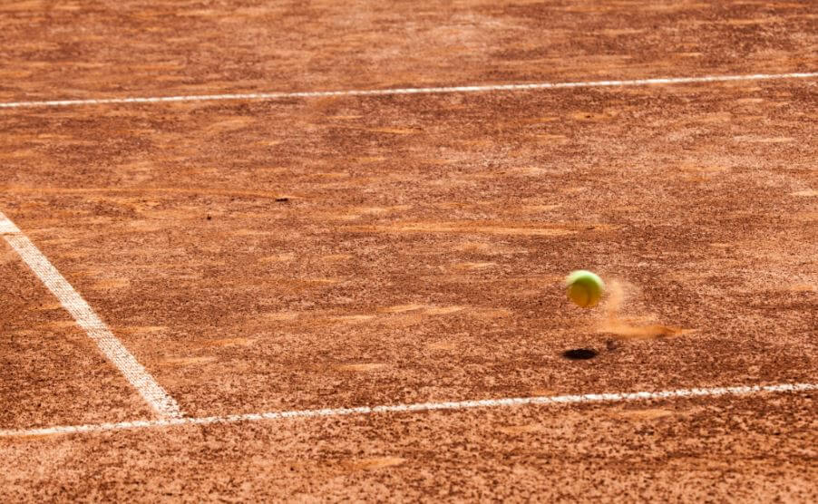 balle de tennis rebondissant sur de la terre battue