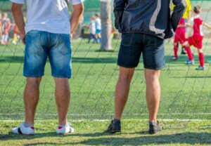 Des parents qui assistent au match de foot d'enfants.