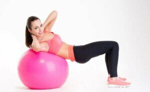 Une femme qui fait des abdominaux avec un ballon.
