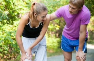 Un couple qui fait du sport en plein air, la femme a mal au genou.