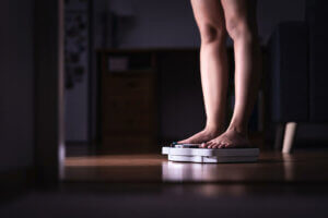 Une femme qui se pèse sur une balance.
