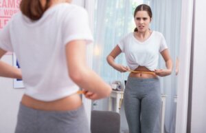 Une femme qui mesure sa taille.