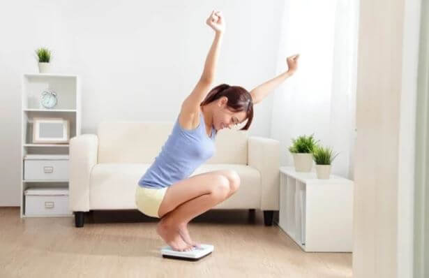 Une femme heureuse sur une balance.