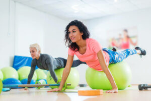 Deux femmes qui font des abdominaux sur un ballon de stabilité.