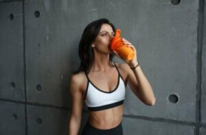 Une femme qui boit un shake de protéines.