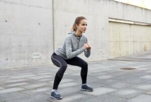 Une femme fait des squats.