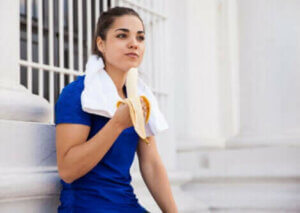 Une femme mangeant une banane.