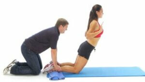 Une femme qui fait un Nordic curl.