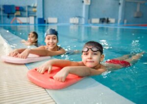 Trois enfants au bord d'une piscine.